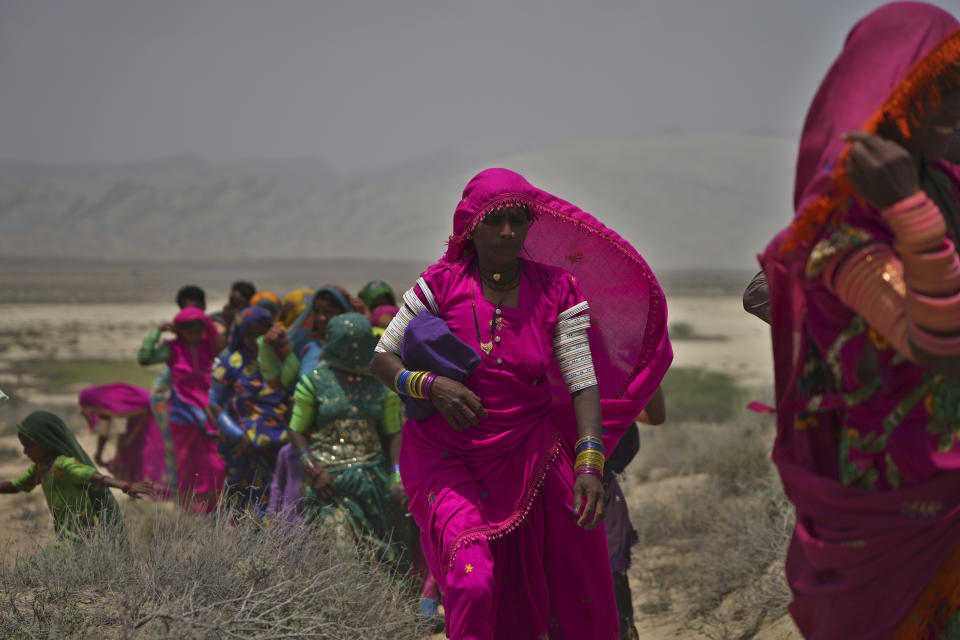 Hindu devotees walk toward a mud volcano to start Hindu pilgrims' religious rituals for an annual festival in an ancient cave temple of Hinglaj Mata in Hinglaj in Lasbela district in the Pakistan's southwestern Baluchistan province, Friday, April 26, 2024. More than 100,000 Hindus are expected to climb mud volcanoes and steep rocks in southwestern Pakistan as part of a three-day pilgrimage to one of the faith's holiest sites. (AP Photo/Junaid Ahmed)