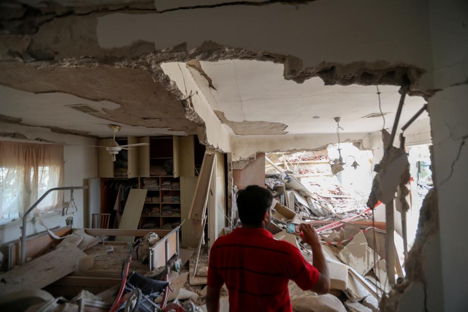 A man inspects a heavily damaged home after it was struck by a missile fired from the Gaza Strip,in the southern Israeli city of Ashkelon.