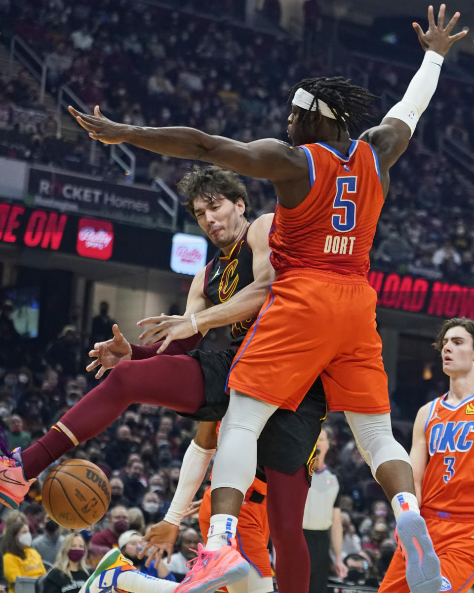 Cleveland Cavaliers' Cedi Osman, right, loses control of the ball against Oklahoma City Thunder's Luguentz Dort (5) in the first half of an NBA basketball game, Saturday, Jan. 22, 2022, in Cleveland. (AP Photo/Tony Dejak)