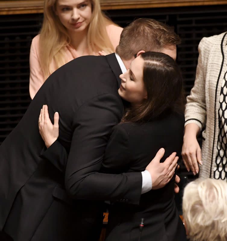 Social democrats minister Sanna Marin receives a hug from Social democrats parliamentary group chairman Antti Lindtman after she was elected as the new Prime Minister of Finland in the session of the Finnish Parliament in Helsinki