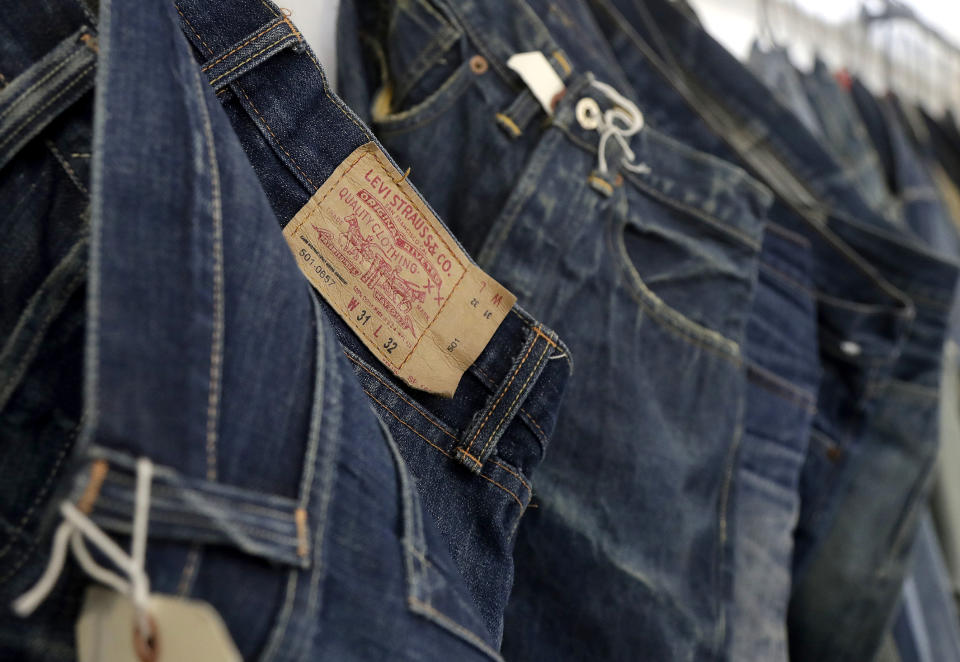 FILE- This Feb. 9, 2018 photo shows Levi's jeans hanging on a wall at Levi's innovation lab in San Francisco. On Thursday, March 21, 2019, Levi Strauss & Co. is going back to the public markets after 34 years. (AP Photo/Jeff Chiu, File)