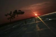 The sun sets behind a road that was built by the government for better connection between Rakhine ethnic villages outside Maungdaw town in northern Rakhine State November 9, 2014. REUTERS/Minzayar