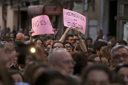 People raise up placards reading "No is no" and "Shame of Justice" during a protest outside Ministry of Justice after a Spanish court condemned five men accused of the group rape of an 18-year-old woman at the 2016 San Fermin bull running festival to nine years in prison each for the lesser crime of sexual abuse in Madrid, Spain, April 26, 2018. REUTERS/Sergio Perez