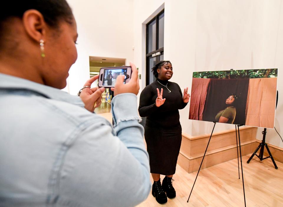 Miya takes a photo of Payton as she poses next o a photo of herself as the ACLU and TKO launch the Black Trans Futures storytelling project during an arts event at the Montgomery Museum of Fine Arts in Montgomery, Ala., on Thursday October 27, 2022. 