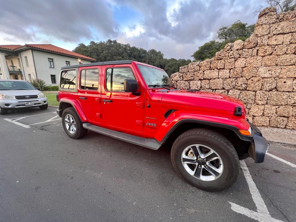 red jeep parked on the side of the road in hawaii