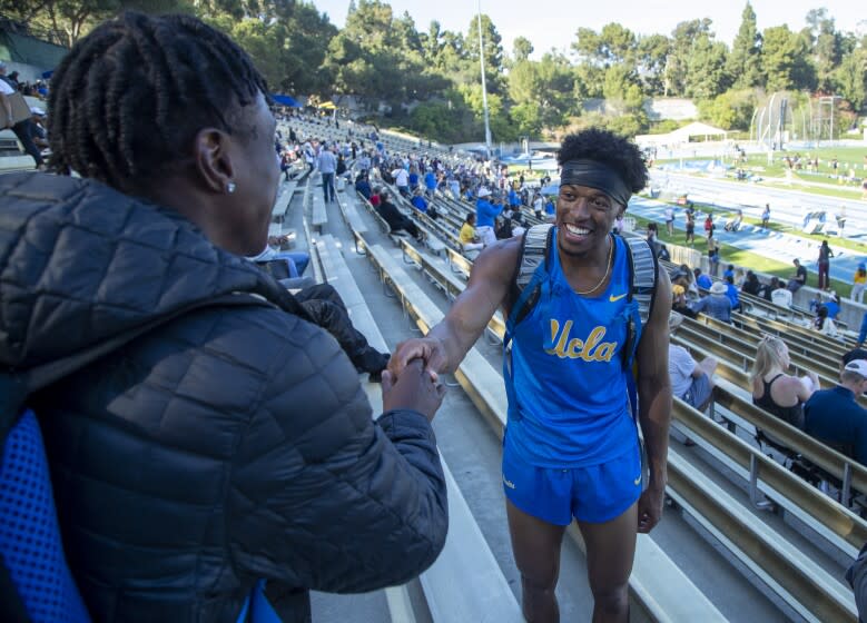 Westwood, CA - March 26: UCLA sophomore track and field athlete Zaylon Thomas, right, greets friend Cam Johnson, left, competing in the 200m race at the Rafer Johnson/Jackie Joyner-Kersee Invitational at Drake Stadium Saturday, March 26, 2022 in Westwood, CA. (Brian van der Brug / Los Angeles Times)