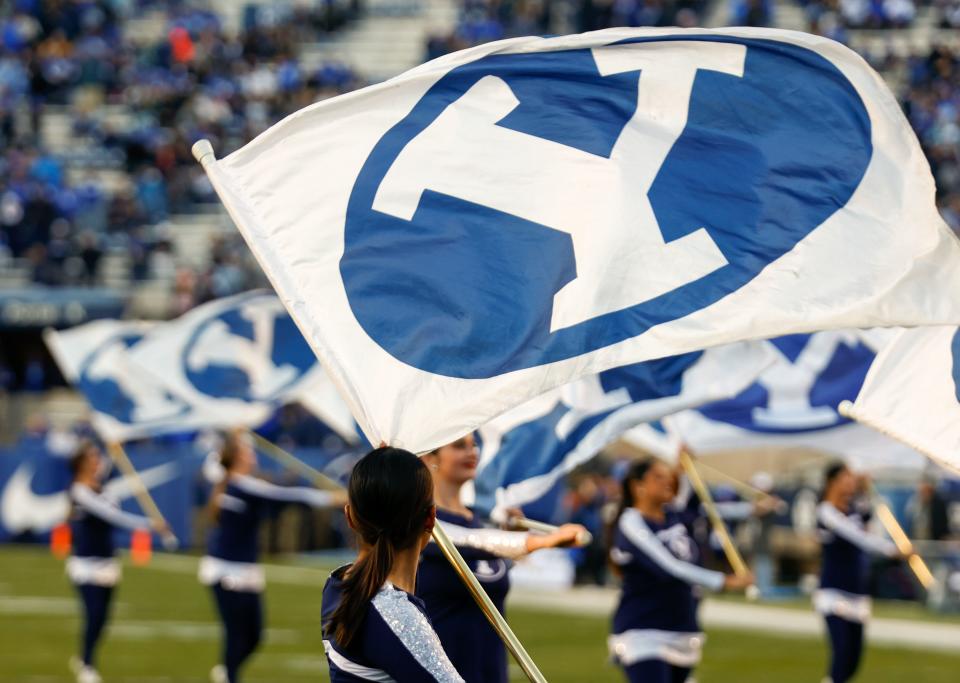 Cheerleaders wave flags at LaVell Edwards Stadium in Provo before a BYU football game on Friday, Oct. 28, 2022.