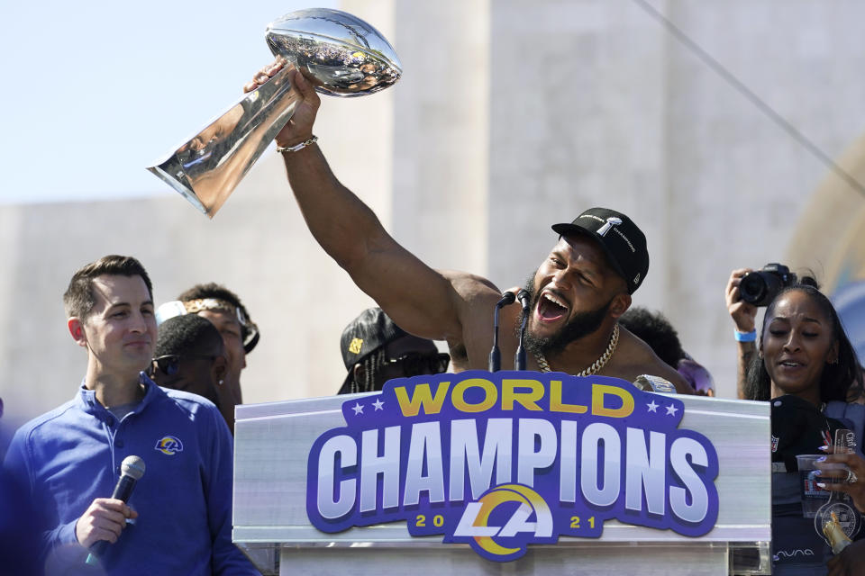 FILE - Los Angeles Rams defensive lineman Aaron Donald holds up the Vince Lombardi Super Bowl trophy during the team's victory celebration and parade in Los Angeles, Wednesday, Feb. 16, 2022. Defensive lineman Aaron Donald has announced his retirement after a standout 10-year career with the Los Angeles Rams. The three-time AP NFL Defensive Player of the Year made his surprising announcement on social media Friday, March 15, 2024. (AP Photo/Marcio Jose Sanchez)