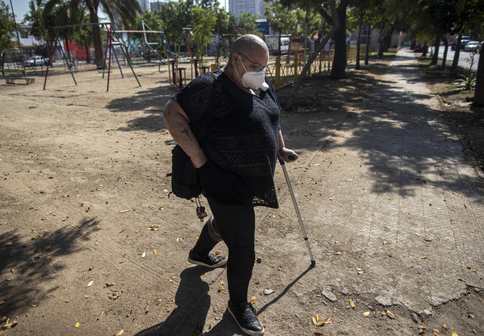 Cecilia Heyder, una activista chilena por el derecho a una muerte digna y que sufre de cáncer metastásico, lupus y un trastorno sanguíneo, camina después de una entrevista con The Associated Press en un parque en Santiago, Chile, el 15 de abril de 2021. La Cámara de Diputados chilena aprobó el martes 20 de abril un proyecto de ley para permitir la eutanasia y el suicidio asistido para los mayores de 18 años, el que ahora será debatido en el Senado. (Foto AP/Esteban Félix)