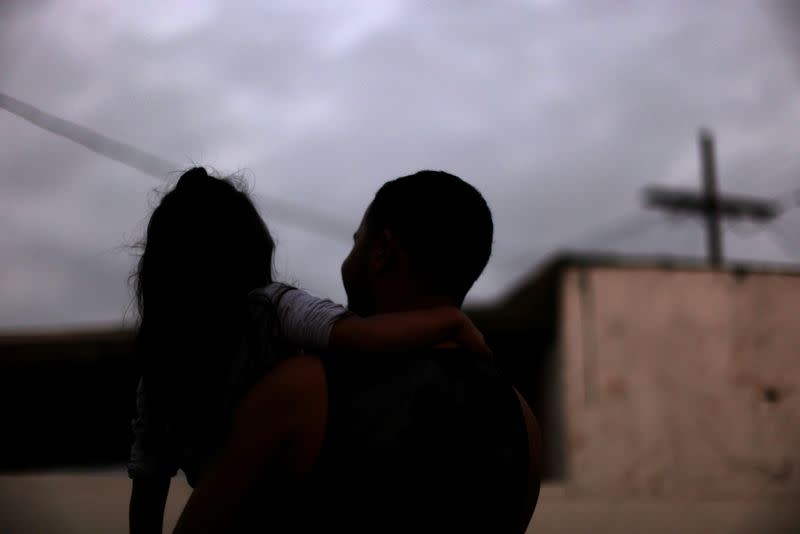 Maynor, 32, carries his daughter at his home in Los Angeles