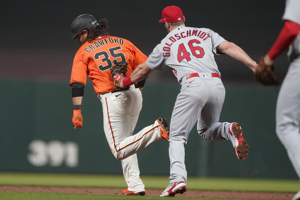 San Francisco Giants' Brandon Crawford, left, is tagged out by St. Louis Cardinals first baseman Paul Goldschmidt (46) during a rundown during the sixth inning of a baseball game in San Francisco, Friday, May 6, 2022. (AP Photo/Jeff Chiu)