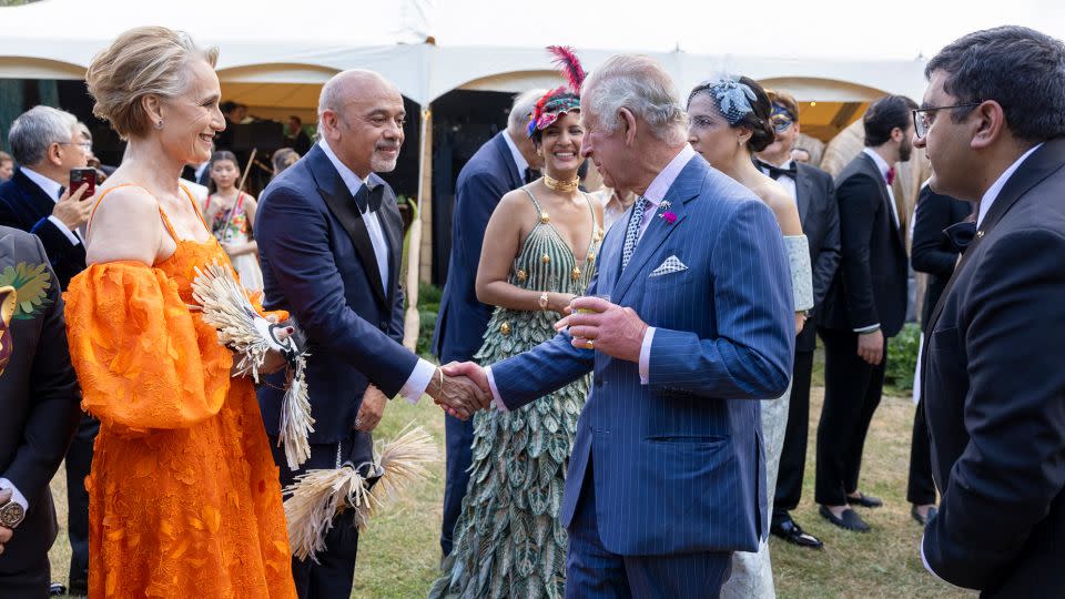 King Charles III speaks with Christian Louboutin and actor Kristin Scott Thomas at a garden party in 2023 in London. - Heathcliff O'Malley/WPA Pool/Getty Images