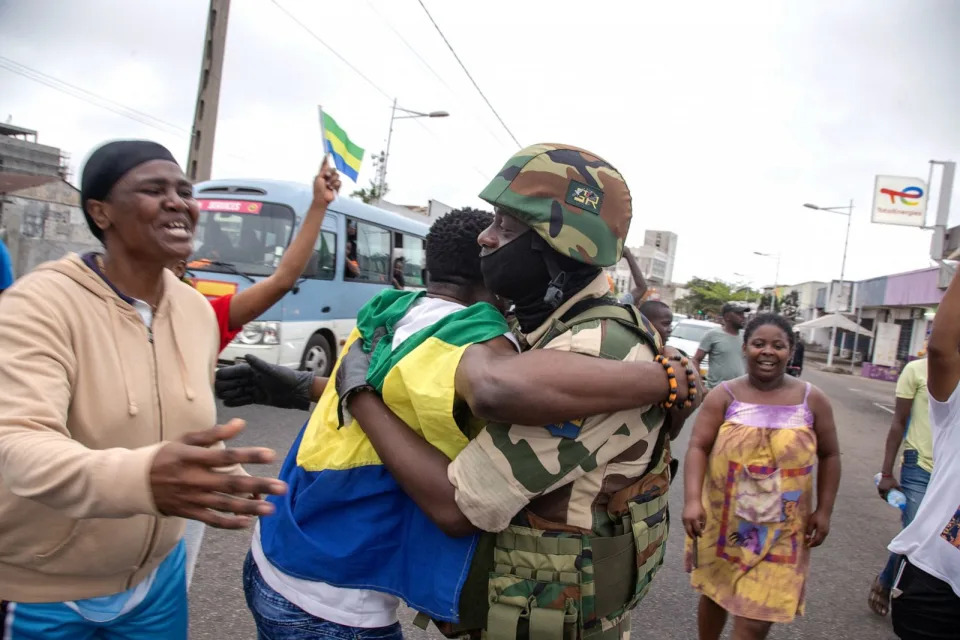 PHOTO: A joyful Gabonese embracing a Republican Guard soldier in front of the presidency in Port-Gentil (economic capital), on Aug. 30, 2023 after the announcement of the Coup d'Etat perpetrated by the Gabonese Defense and Security Forces. (Desirey Minkoh/Afrikimages Agency/Universal Images Group via Getty Images)