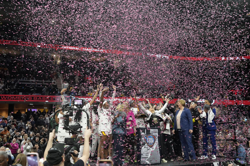 South Carolina players and coach celebrate after the Final Four college basketball championship game against Iowa in the women's NCAA Tournament, Sunday, April 7, 2024, in Cleveland. South Carolina won 87-75. (AP Photo/Morry Gash)