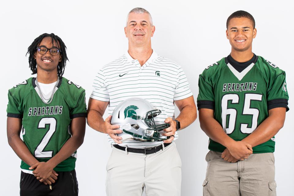 York Tech football players KingZion Matai (2) and Pearce Alleyne (65) pose for a photo with head coach Scott Mathena during YAIAA football media day on Tuesday, August 1, 2023, in York.