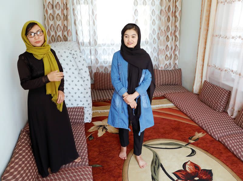 Shamsia Alizada,18, who has come top in the country's university entrance exam, stands beside her mother after an interview at her house in Kabul