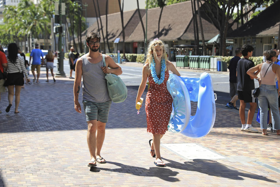 Joe Detillio, 26, left, and Katherine Knapp, 24, both from Albany, NY, walk in Waikiki, Thursday, June, 23, 2022 in Honolulu. In a major expansion of gun rights after a series of mass shootings, the Supreme Court said Thursday that Americans have a right to carry firearms in public for self-defense.