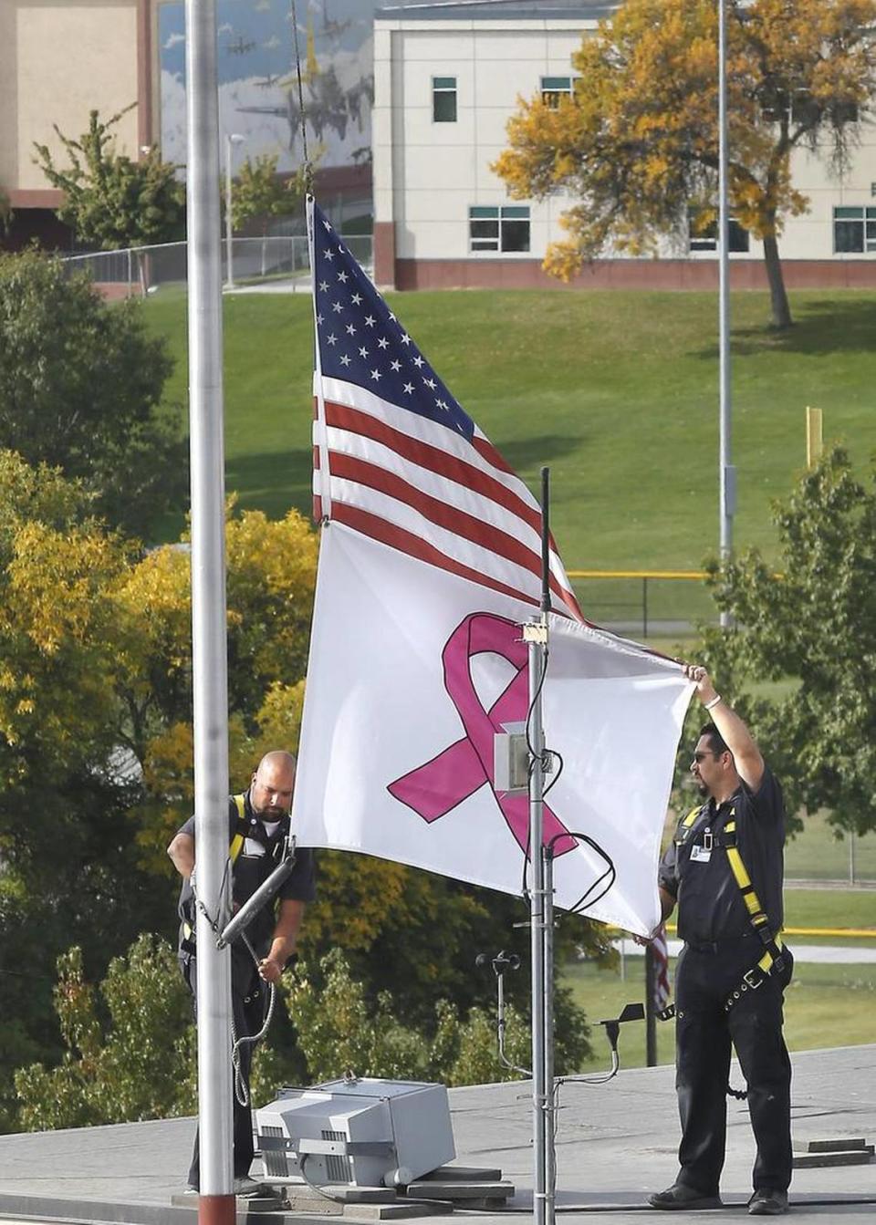 Kadlec Regional Medical Center employees raise a breast cancer awareness flag on the roof of Kadlec Regional Medical Center in Richland.