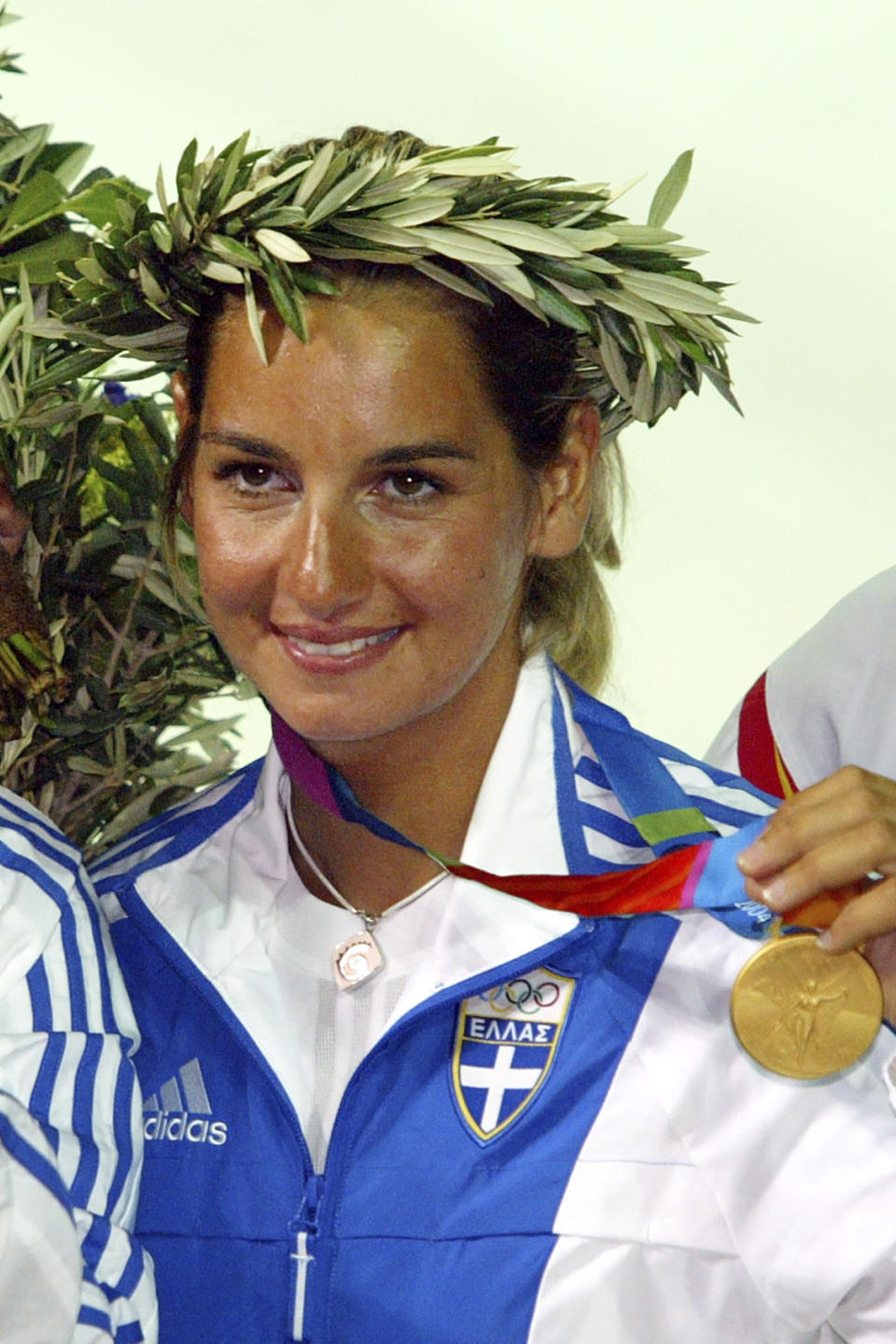 FILE - In this Saturday, Aug. 21, 2004 file photo, Greek 470 class skipper Sofia Bekatorou, displays her gold medal during the medal ceremony of the women's double-handed 470 dinghy sailing event at the 2004 Olympic Games in Athens, Greece. Olympic sailing champion Sofia Bekatorou of Greece has accused an unnamed sporting official of sexually assaulting her in 1998 during preparations for the Sydney Games. Bekatorou made the allegation Thursday Jan. 14, 2021 while speaking at an online event organized by the ministry of culture and sport. (AP Photo/Herbert Knosowski, file)