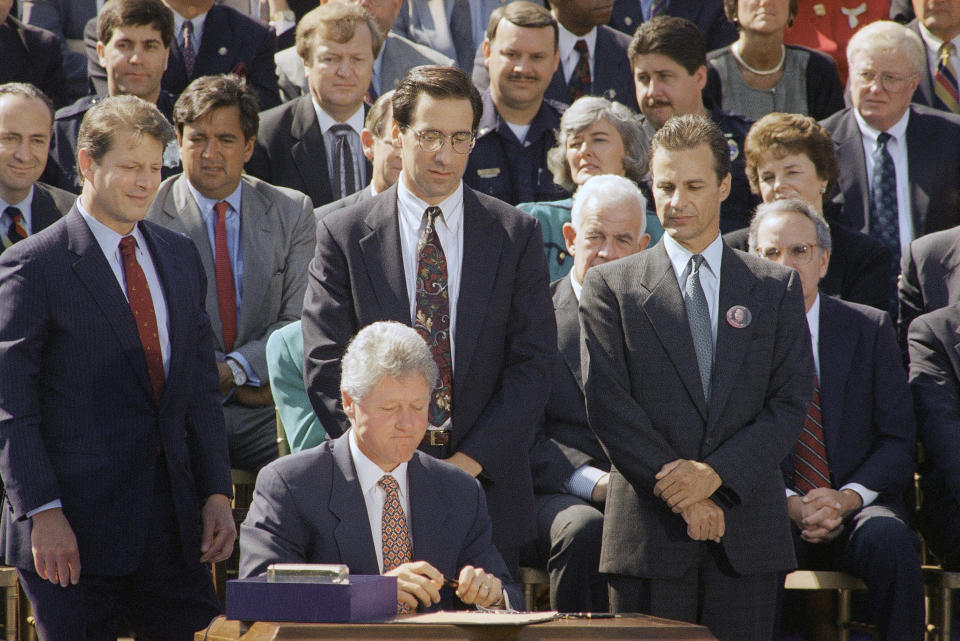 Stephen Sposato, whose wife was killed when a gunman invaded the San Francisco law firm where she worked, left, and Marc Klass, whose daughter was kidnapped and killed, right, look on as President Bill Clinton signs a $30 billion crime bill