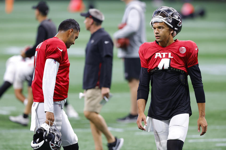 Atlanta Falcons quarterbacks Marcus Mariota (1) and Desmond Ridder (4) warm up during the NFL football team's open practice in Atlanta on Monday, Aug. 15, 2022. (AP Photo/Todd Kirkland)