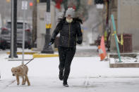 A woman wears a protective mask as she walks her dog down the sidewalk in Zelienople, Pa., Thursday, Jan. 28, 2021. Irritated by the sweeping use of executive orders during the COVID-19 crisis, state lawmakers around the U.S. are moving to curb the authority of governors and top health officials to impose emergency restrictions such as mask rules and business shutdowns. (AP Photo/Keith Srakocic)