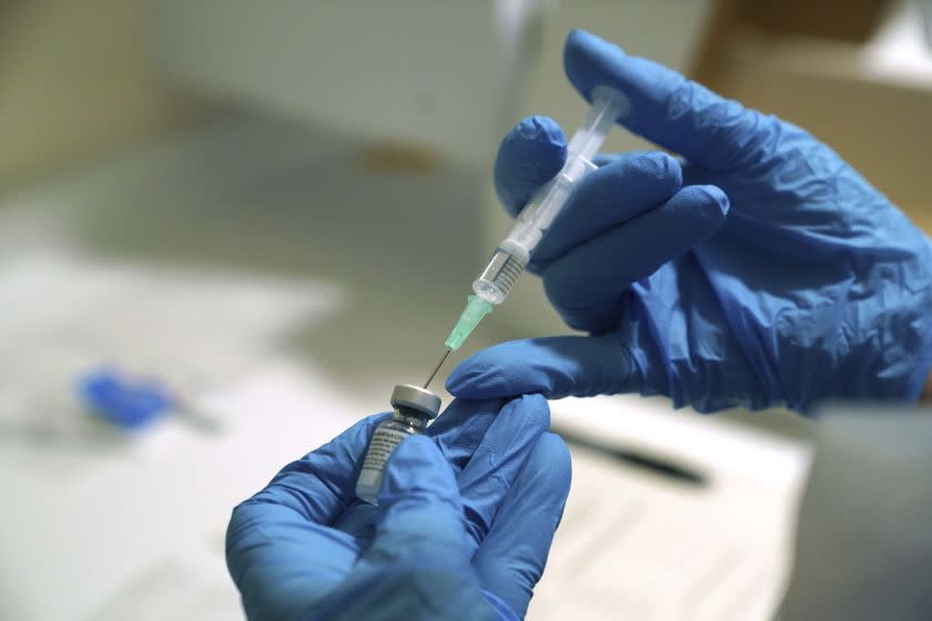 A Pfizer-BioNTech COVID-19 vaccine is prepared at the Royal Victoria Infirmary in Newcastle, England, Tuesday Dec. 8, 2020. The United Kingdom, one of the countries hardest hit by the coronavirus, is beginning its vaccination campaign, a key step toward eventually ending the pandemic. (Owen Humphreys/Pool via AP)