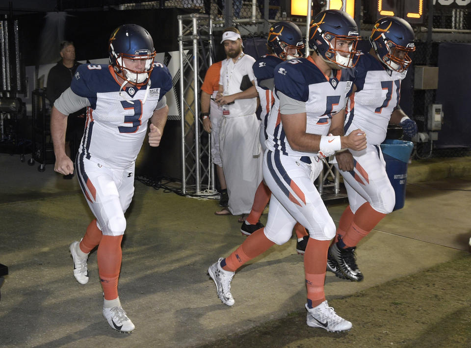 FILE - In this Feb. 9, 2019, file photo, Orlando Apollos quarterbacks Garrett Gilbert (3), and Austin Appleby (5) and offensive lineman Ronald Patrick (71) run onto the field before the team's Alliance of American Football game against the Atlanta Legends, in Orlando, Fla. Almost no one knows the players, and there’s virtually no history to look back on. But that’s not stopping people from making _ and bookmakers from taking _ bets on America’s newest professional football league, the Alliance of American Football (AAF).(AP Photo/Phelan M. Ebenhack, File)