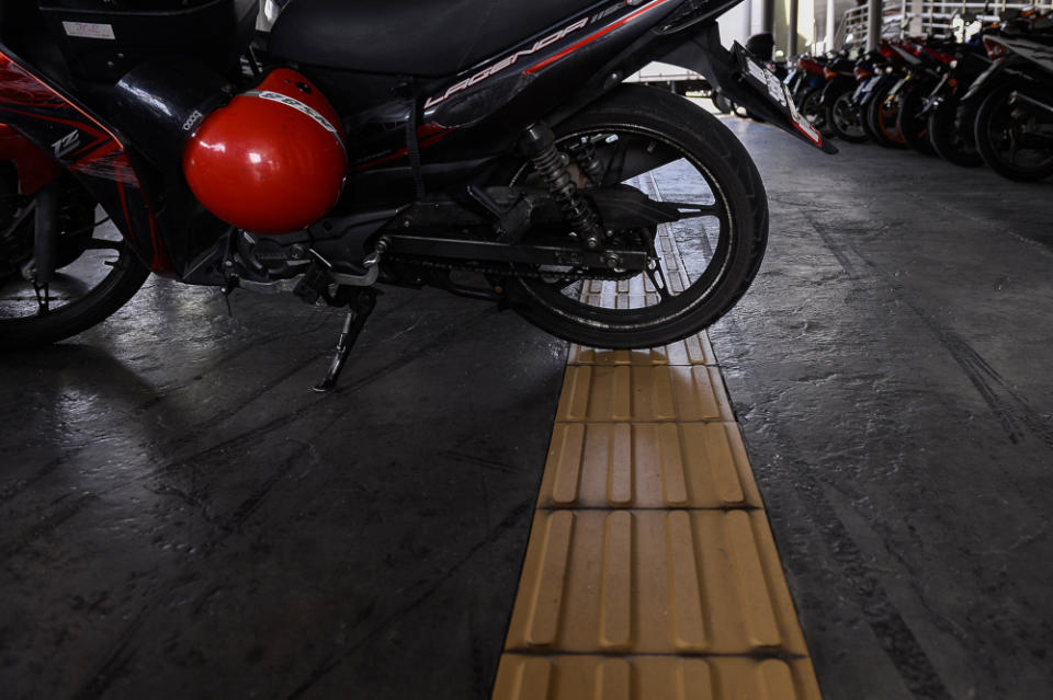 Vehicles parked on a pedestrian walkway for people with disabilities. — Picture by Miera Zulyana