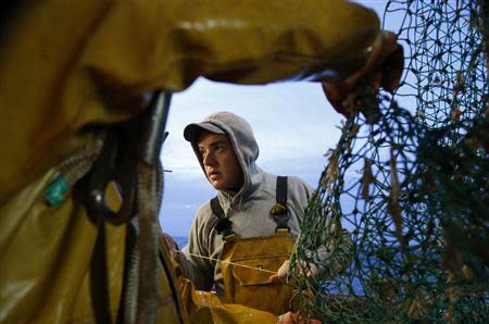 Vincent Margolle, a fisherman on the Boulogne sur Mer based trawler "Nicolas Jeremy", mends fishing nets off the coast of northern France October 21, 2013. REUTERS/Pascal Rossignol