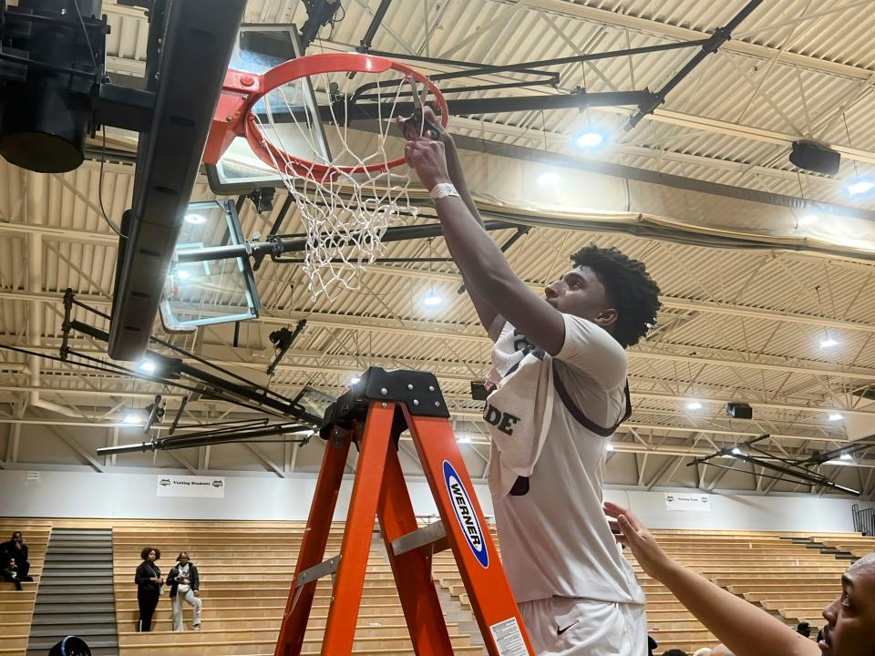 Brandon Roddy cuts a piece of the net after helping Harvest Prep to a 62-61 win over Africentric in a Division III district final Thursday at Ohio Dominican.