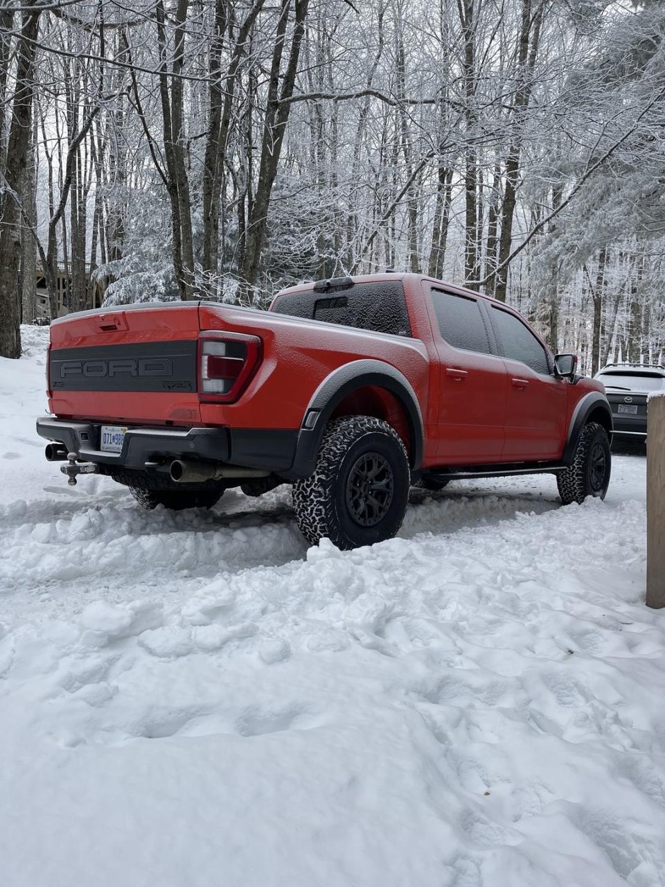 orange ford raptor in the snow