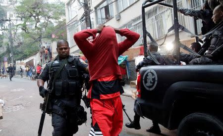 A police officer arrests a suspected drug dealer after a shootout during a police operation at Pavao-Pavaozinho slum in Rio de Janeiro, Brazil, October 10, 2016. REUTERS/Ricardo Moraes