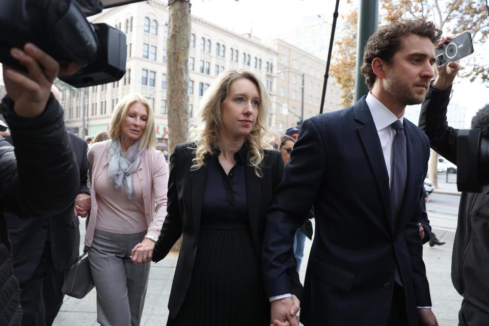 Former Theranos CEO Elizabeth Holmes (C) arrives at federal court with her partner Billy Evans (R) and mother Noel Holmes on November 18, 2022 in San Jose, California (Getty Images)