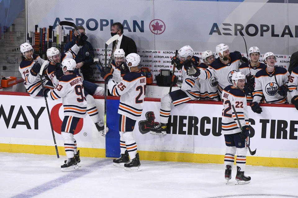 The Edmonton Oilers bench celebrates after their game-winning goal with less than a second left against the Winnipeg Jets in an NHL hockey game, Sunday, Jan. 24, 2021, in Winnipeg, Manitoba. (Fred Greenslade/The Canadian Press via AP)