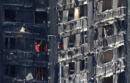 Members of the emergency services work inside burnt out remains of the Grenfell apartment tower in North Kensington, London, Britain, June 18, 2017. REUTERS/Neil Hall