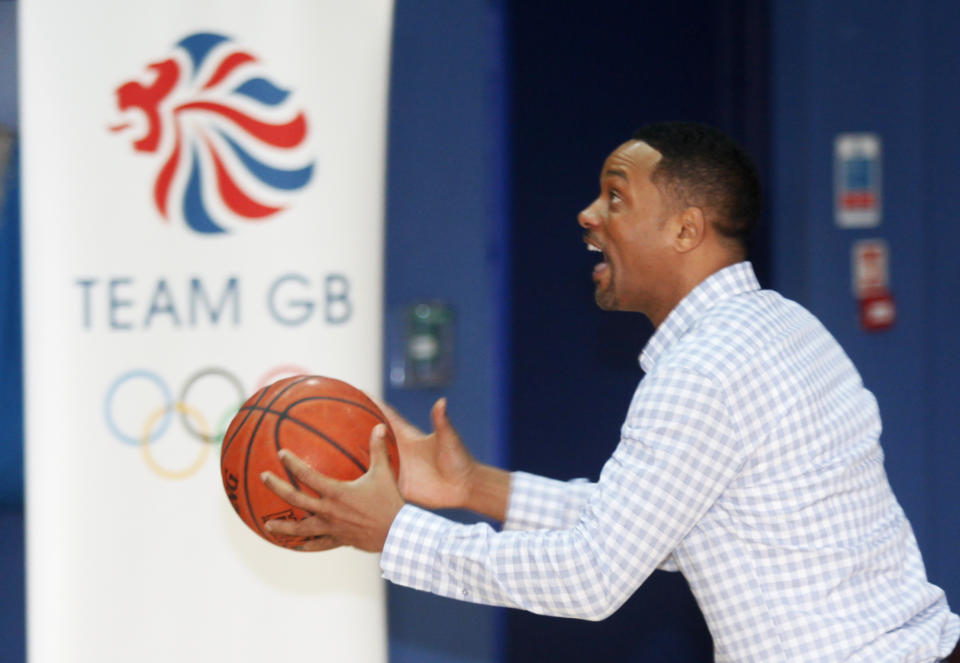 Actor Will Smith goes for layup against Great Britain Olympic team basketball captain Drew Sullivan at Ethos gym in London, Wednesday, May 16, 2012. (AP Photo/Jim Ross)