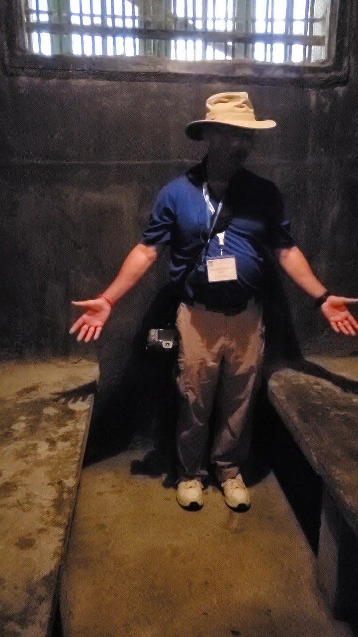 Visiting the former 'Hanoi Hilton' prison in 2023, David Drummond stands in a prison cell similar to the one where he was held as a prisoner of war during the Vietnam War.