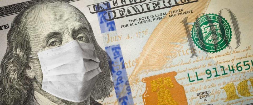 One Hundred Dollar Bill With Medical Face Mask on Benjamin Franklin.