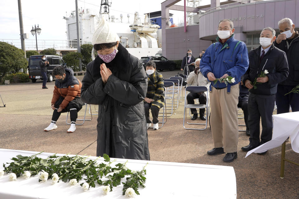 People offer flowers for the victims of a resettlement program led by North Korea, at a commemoration ceremony held at a port in Niigata, Japan on Dec. 14, 2021. Some 93,000 ethnic Korean residents in Japan and their relatives joined the program only to find the opposite of what was promised. Most were put to brutal manual labor at mines, in forests and on farms and faced discrimination because of Japan's past colonization of the Korean Peninsula. (AP Photo/Chisato Tanaka)