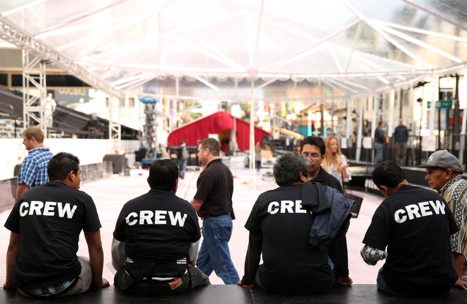 Members of the setup crew take a break on the red carpet as preparations are made for the 86th Academy Awards in Los Angeles, Wednesday, Feb. 26, 2014. The Academy Awards will be held at the Dolby Theatre on Sunday, March 2. (Photo by Matt Sayles/Invision/AP)