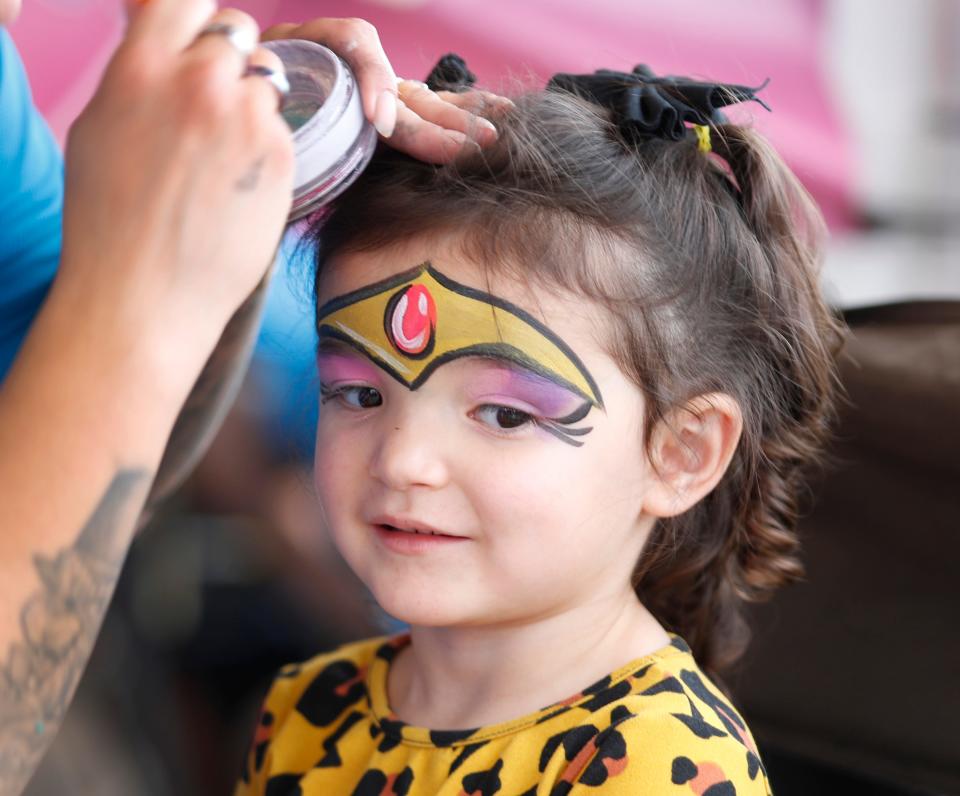 Three-year-old Amyah Alcorte, of Lubbock, gets her face painted at the Facepaint booth during preview night at the Panhandle South Plains Fair Thursday, September 21, 2023.