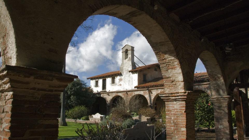 historic mission building framed by an arch