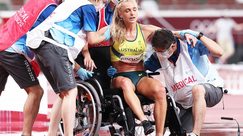 Genevieve Gregson is helped into a wheelchair by officials after falling during the steeplechase at the Tokyo Olympics.