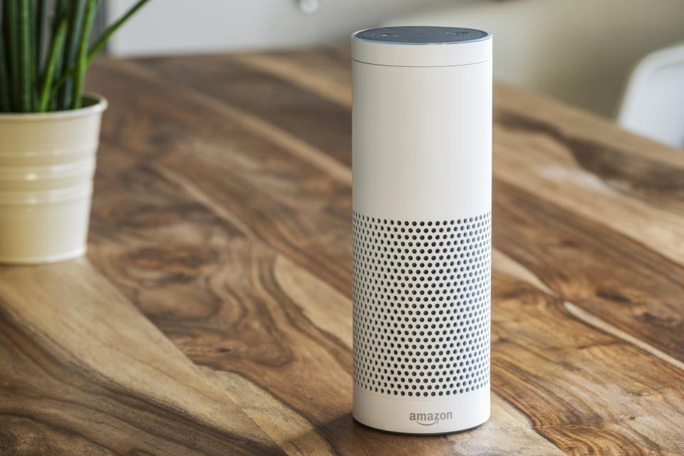 MUENSTER - JANUARY 27, 2018: White Amazon Echo Plus, Alexa Voice Service activated recognition system photographed on wooden table in living room, Packshot showing Amazon Logo