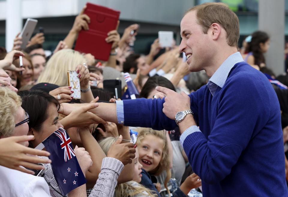 Britain's Prince William reacts as he shakes hands with members of the crowd before boarding an America's Cup yacht on Auckland Harbour