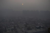 FILE - In this Jan. 2, 2021, file photo, the morning sun is seen through a blanket of smog on the outskirts of New Delhi, India. India has ambitions to expand use of electric vehicles to wean itself from polluting fossil fuels, but EVs are still a rarity on its congested highways. A lack of charging stations and poor quality batteries are discouraging drivers from switching over. (AP Photo/Altaf Qadri, File)