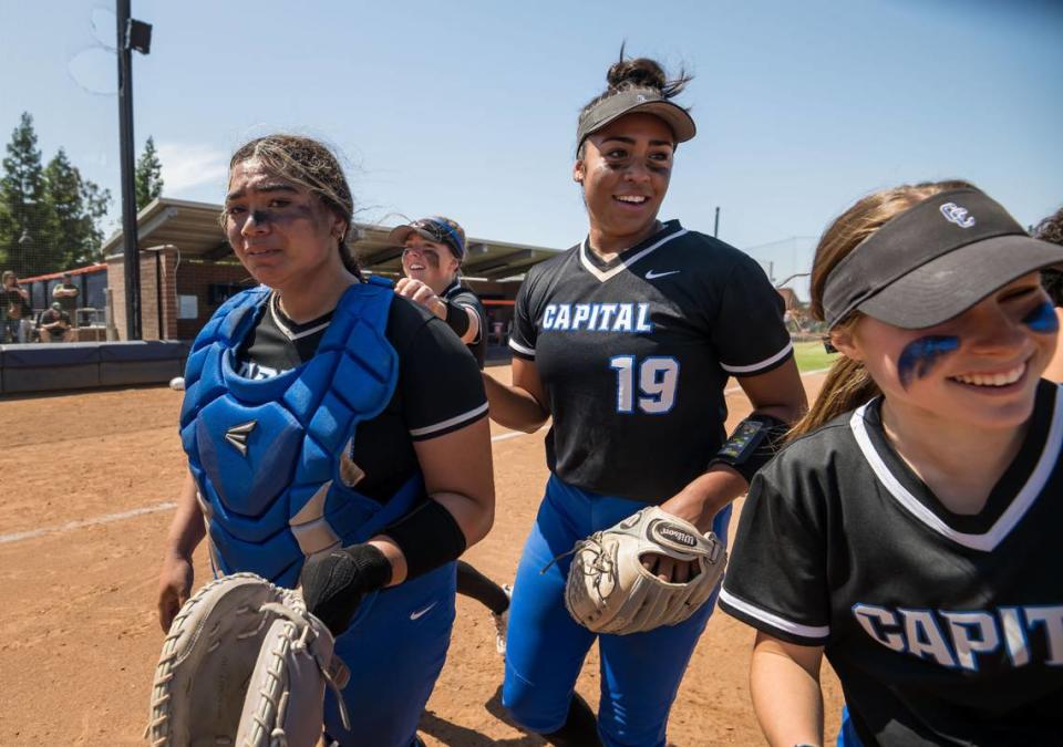 Capital Christian Cougars catcher Nani Lose-Mahina (21), left, pitcher Ayla Tuua (19) and teammates walk off the field after their win over the Dixon Rams at the CIF Sac-Joaquin Section Division IV high school softball championship game Saturday, May 27, 2023, at Cosumnes River College.