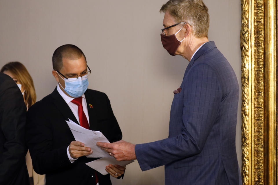 Robert Schuddeboom, Charge d'Affaires for the Netherlands, right, receives a protest letter from Venezuelan Foreign Minister Jorge Arreaza at the Foreign Ministry headquarters in Caracas, Venezuela, Wednesday, Feb. 24, 2021, amid the COVID-19 pandemic. The meeting was called after the EU sanctioned an additional 19 Venezuelans for "undermining democracy and the rule of law" in Venezuela and the National Assembly declared the EU ambassador "persona non grata." (AP Photo/Ariana Cubillos)