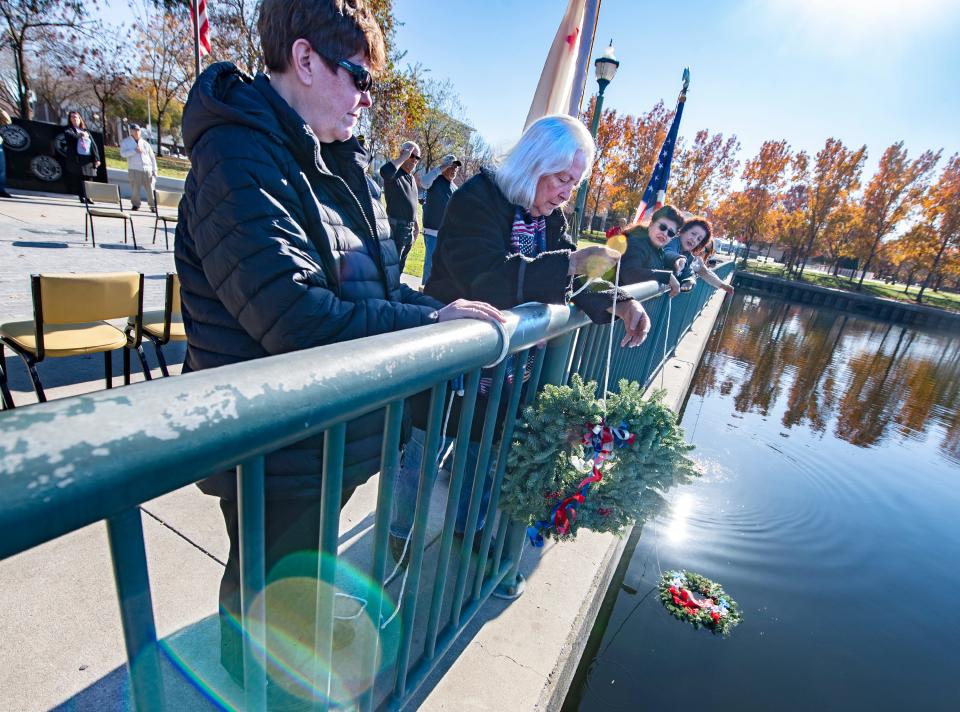 Donna Shane, left, and Rosie Buster, representing American Legion Ed Stewart Post 803, lower a wreath into the water during the Pearl Harbor Day observance at McLeod Lake Park in downtown Stockton on Wednesday, Dec. 7, 2022.